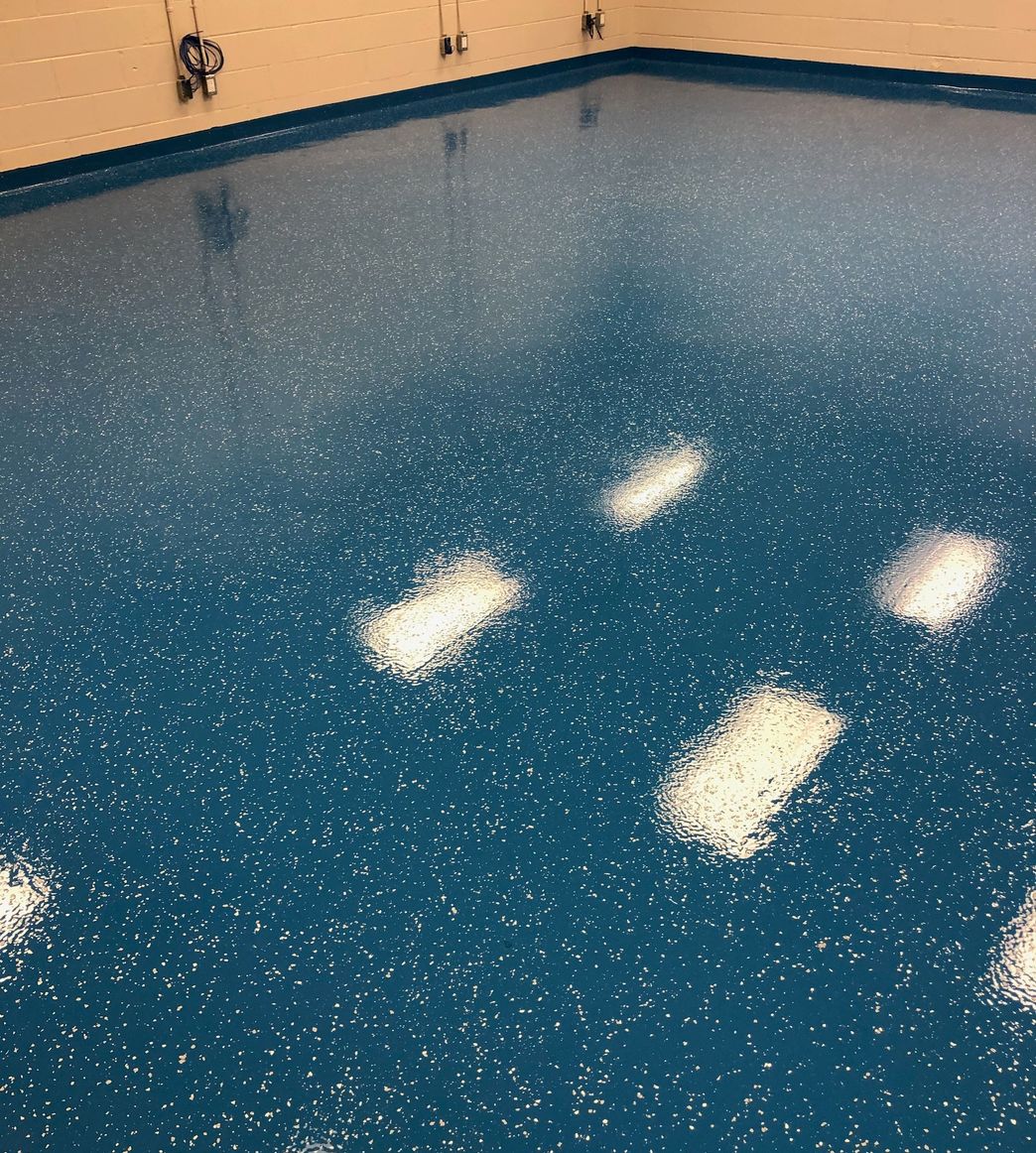 Blue decorative epoxy flooring with
				flakes