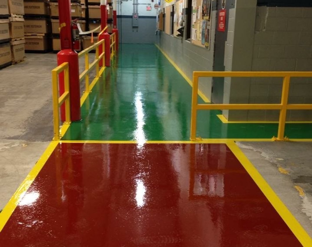 Green and red epoxy safety walkways installed in a Toronto industrial warehouse