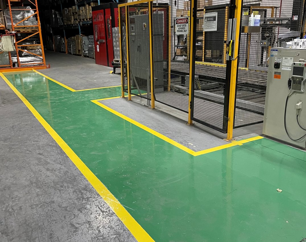 Green safety walkway with yellow border lines in a Toronto industrial facility