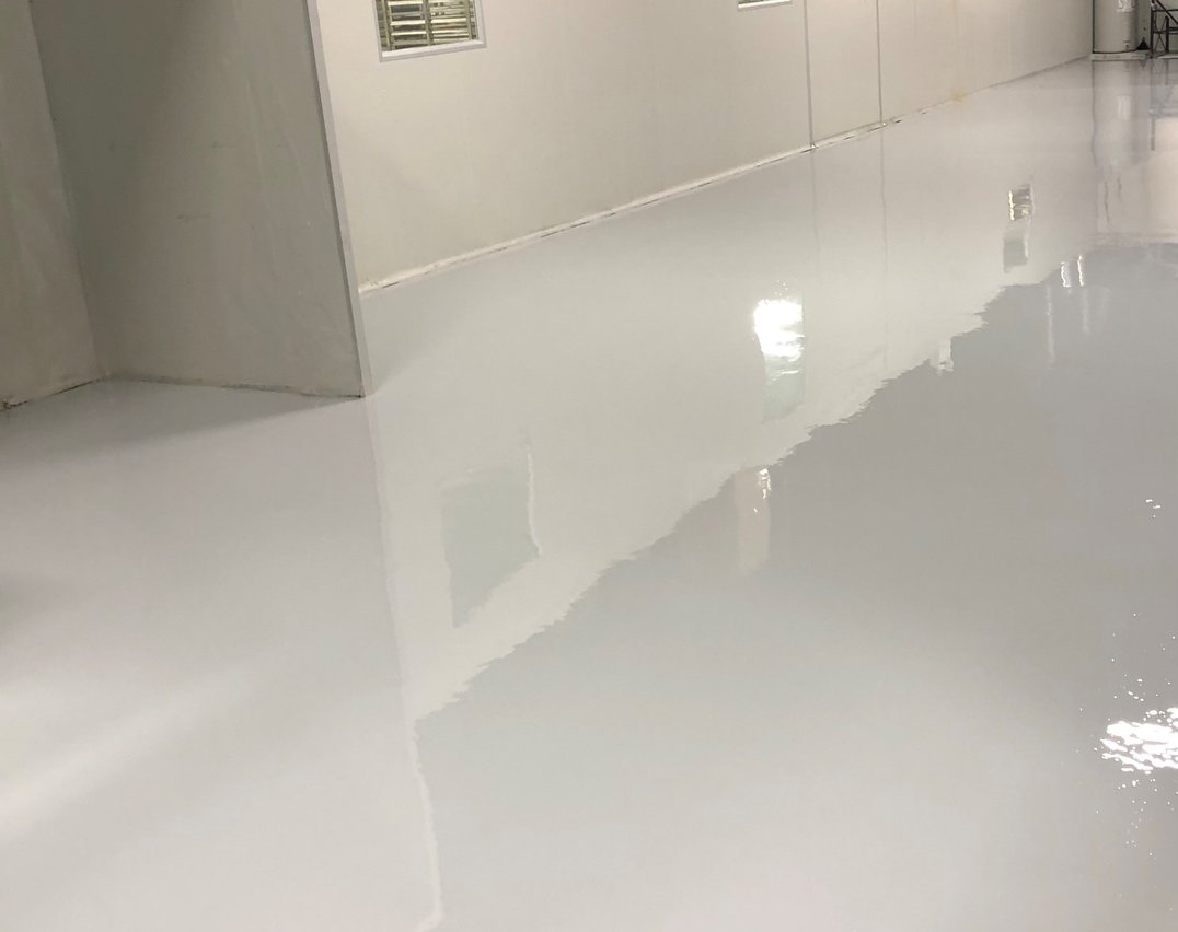 Open laboratory space with gray epoxy flooring in a Toronto pharmaceutical facility