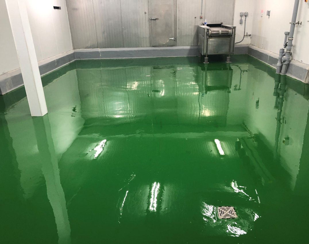 Corner view of green epoxy flooring with cove base in a Toronto food processing facility