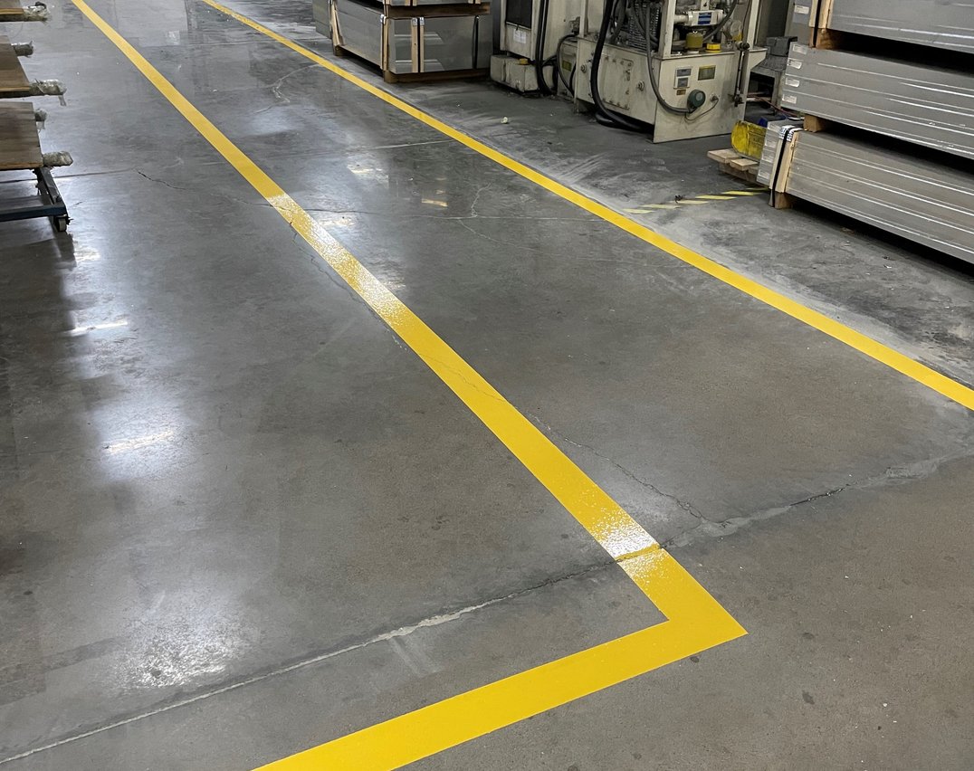 Yellow safety lines marking a pedestrian walkway in a Toronto warehouse